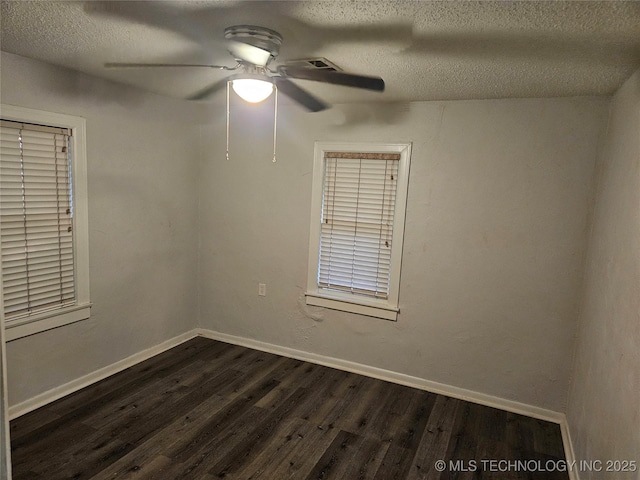 1435 E Oak St, Cushing, OK 74023 - empty room with dark wood-type flooring, a ceiling fan, a textured ceiling, and baseboards