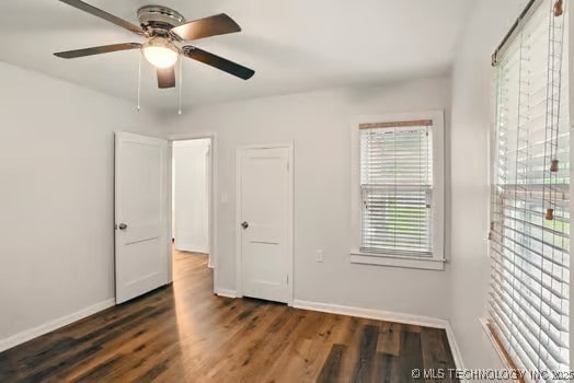 1435 E Oak St, Cushing, OK 74023 - unfurnished bedroom featuring baseboards, wood finished floors, and ceiling fan