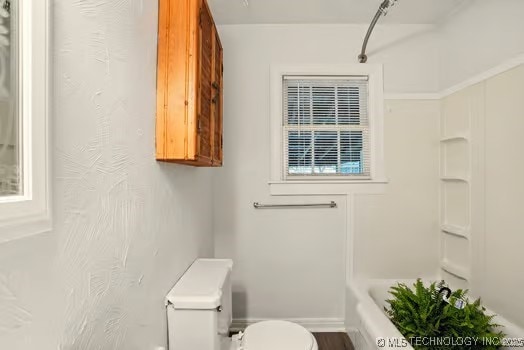 1435 E Oak St, Cushing, OK 74023 - full bathroom featuring toilet and baseboards