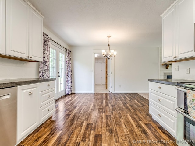 kitchen with dark countertops, range, dark wood-style floors, and white cabinetry