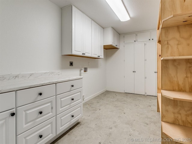 laundry room with hookup for an electric dryer, cabinet space, washer hookup, and baseboards