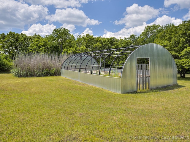 view of greenhouse featuring a lawn