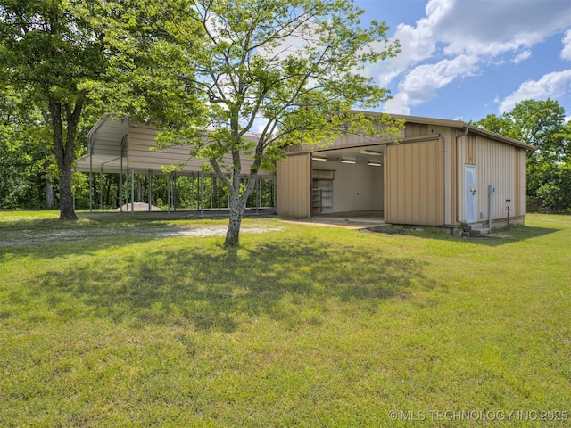 view of grassy yard featuring an outbuilding and a carport