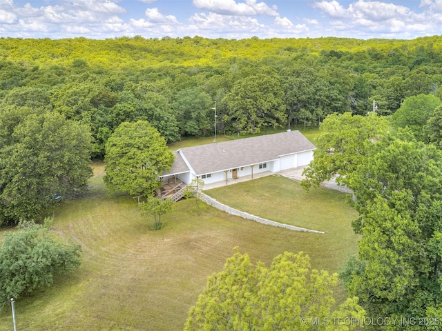 aerial view of property and surrounding area featuring a forest