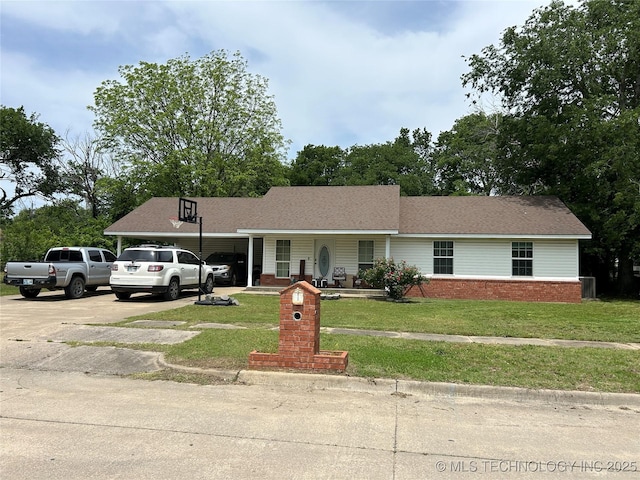 ranch-style home featuring concrete driveway, a front yard, an attached carport, and brick siding