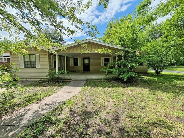303 NW 3rd St, Stigler, OK 74462 - ranch-style house with a porch and a front yard