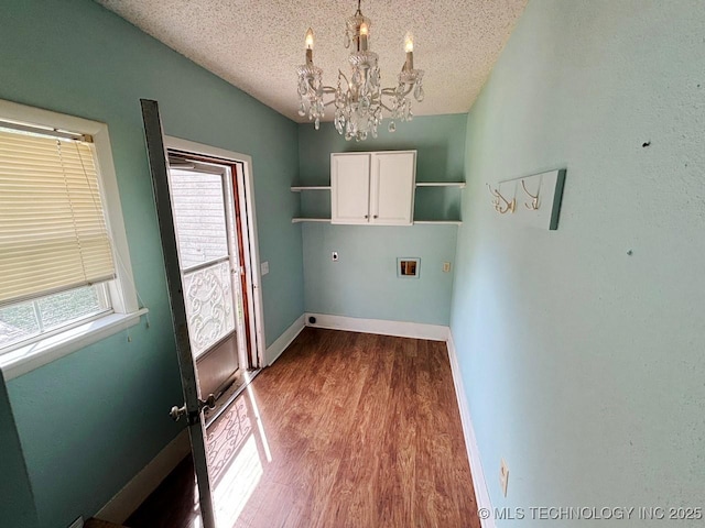 303 NW 3rd St, Stigler, OK 74462 - washroom featuring cabinet space, hookup for a washing machine, hookup for an electric dryer, a chandelier, and wood finished floors
