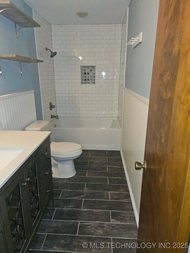110 W 8th St, So Coffeyville, OK 74072 - full bath featuring a wainscoted wall,  shower combination, vanity, a textured ceiling, and toilet