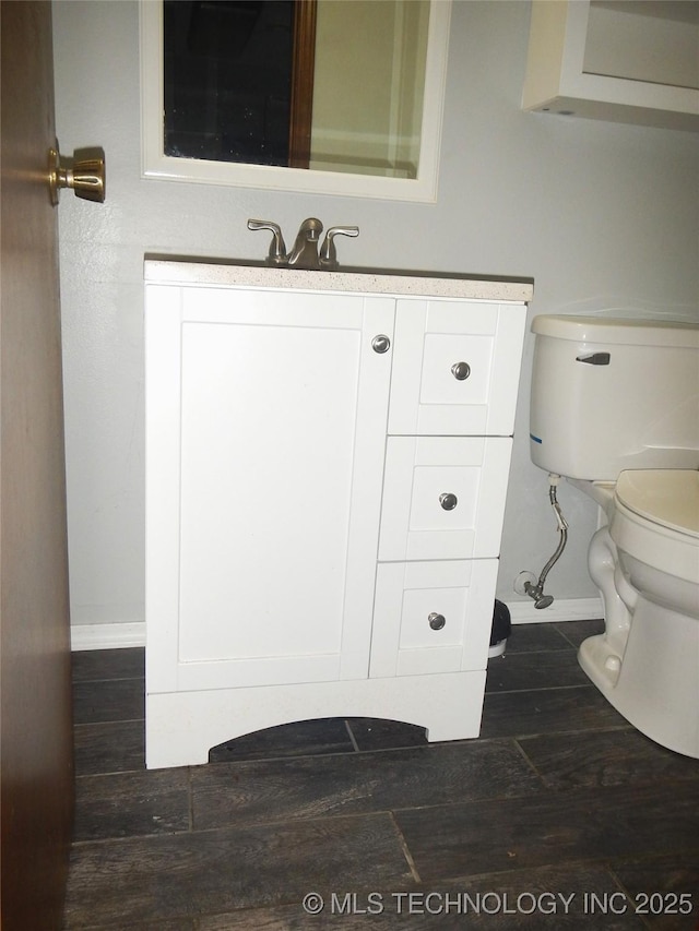 110 W 8th St, So Coffeyville, OK 74072 - half bath with baseboards, toilet, vanity, and wood finished floors