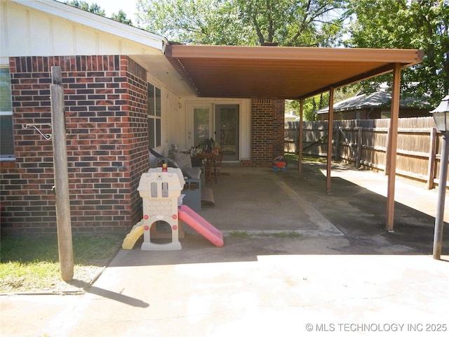 110 W 8th St, So Coffeyville, OK 74072 - view of patio / terrace with fence, french doors, and an attached carport