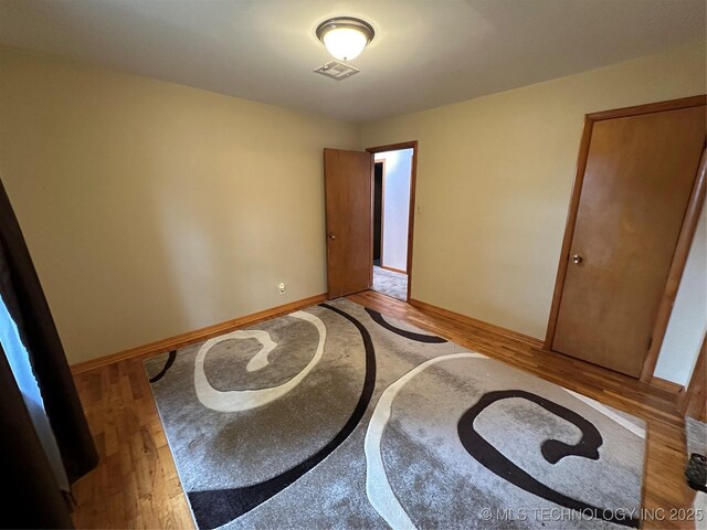 1002 Lakeland St, Checotah, OK 74426 - unfurnished bedroom featuring light wood-style flooring and baseboards
