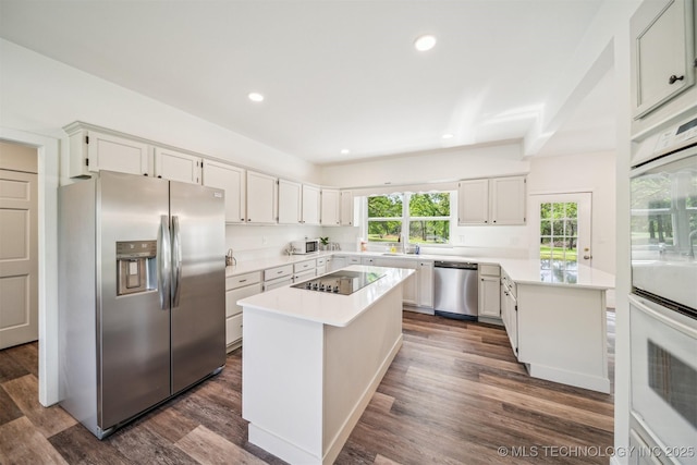 1001 County Road 2265, Skiatook, OK 74070 - kitchen with stainless steel appliances, light countertops, a kitchen island, dark wood-style floors, and recessed lighting