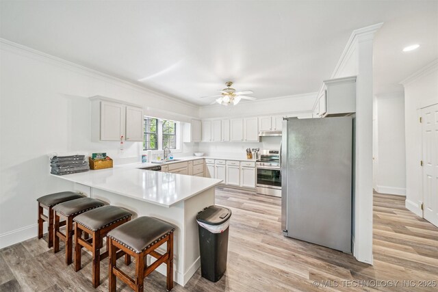 1001 County Road 2265, Skiatook, OK 74070 - kitchen with appliances with stainless steel finishes, a peninsula, ornamental molding, a sink, and ceiling fan
