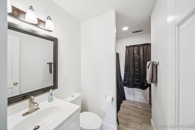 1001 County Road 2265, Skiatook, OK 74070 - full bath featuring toilet, wood finished floors, vanity, baseboards, and recessed lighting