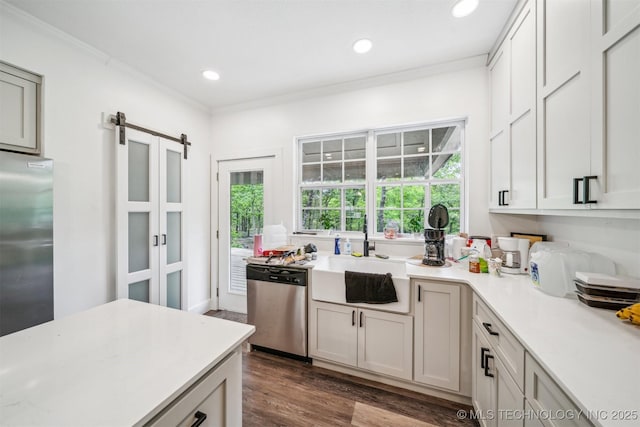 1001 County Road 2265, Skiatook, OK 74070 - kitchen featuring appliances with stainless steel finishes, a sink, a barn door, light countertops, and ornamental molding