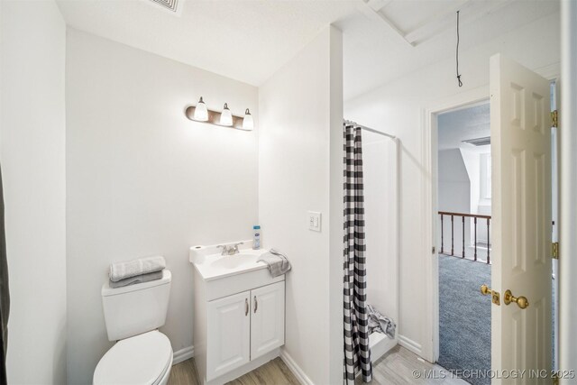 1001 County Road 2265, Skiatook, OK 74070 - full bath featuring toilet, vanity, a shower with curtain, wood finished floors, and baseboards