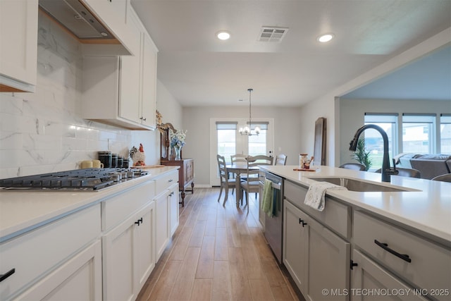 kitchen featuring appliances with stainless steel finishes, a sink, a chandelier, light countertops, and recessed lighting