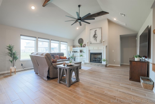 living area with high vaulted ceiling, ceiling fan, a fireplace with raised hearth, baseboards, and recessed lighting