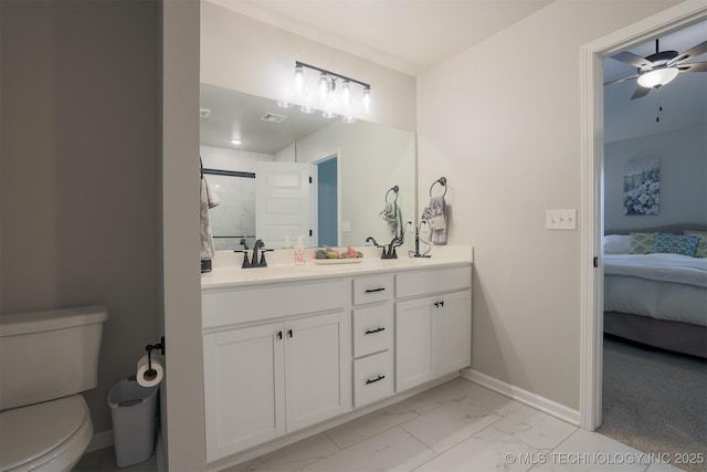 ensuite bathroom with marble finish flooring, baseboards, toilet, a ceiling fan, and a shower stall