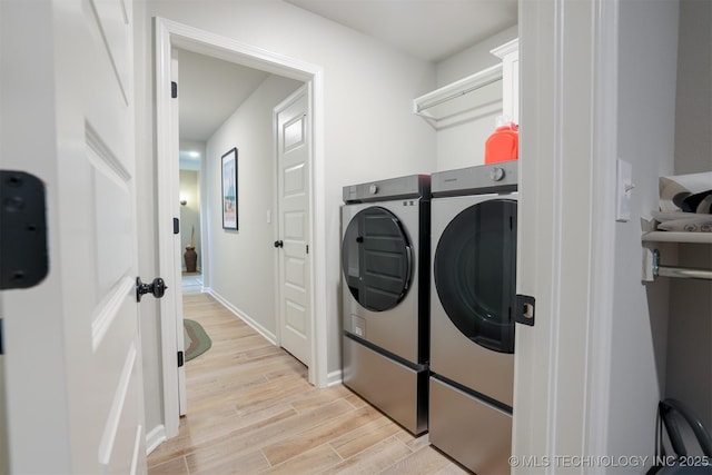laundry room featuring washer and dryer, light wood-style floors, and baseboards