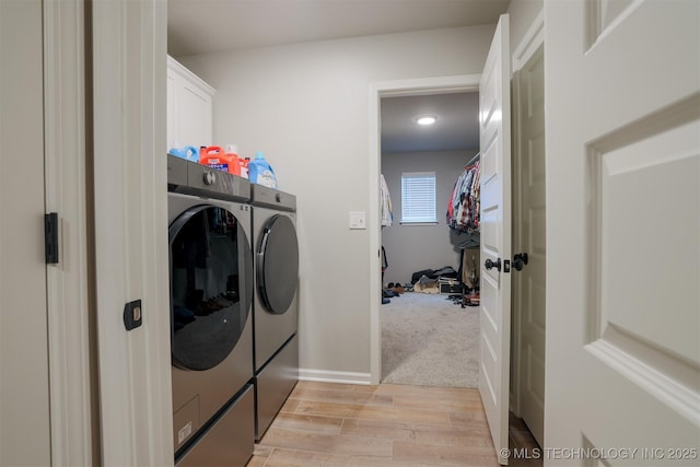 washroom featuring independent washer and dryer, light wood-style flooring, cabinet space, and recessed lighting