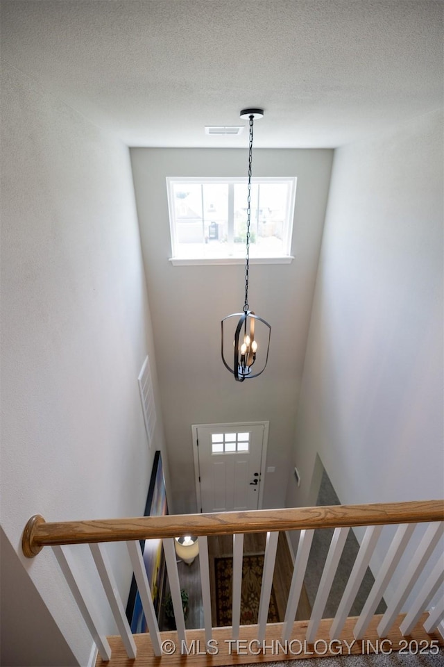 stairs featuring a chandelier and a high ceiling