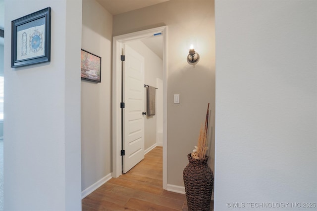hall featuring wood finished floors and baseboards