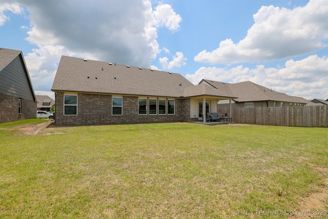 back of property featuring a patio area, brick siding, and roof with shingles