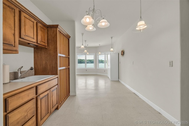 32290 S 630th Rd, Jay, OK 74346 - kitchen with a sink, brown cabinetry, and hanging light fixtures