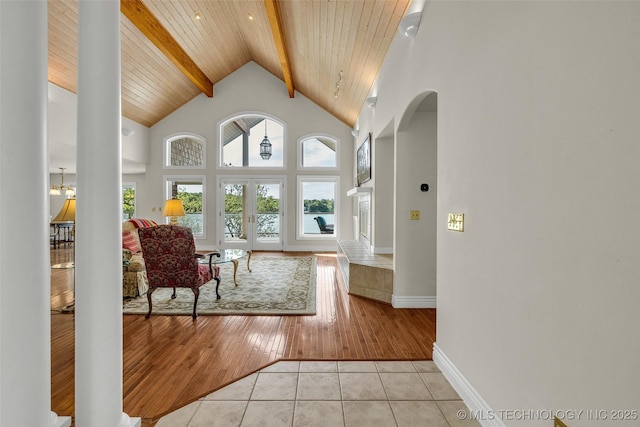 32290 S 630th Rd, Jay, OK 74346 - living room with beamed ceiling, arched walkways, light tile patterned floors, baseboards, and high vaulted ceiling