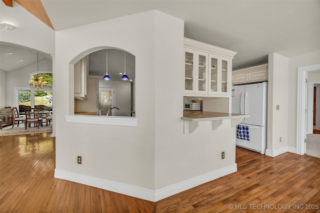 32290 S 630th Rd, Jay, OK 74346 - kitchen with freestanding refrigerator, hardwood / wood-style flooring, glass insert cabinets, baseboards, and a chandelier