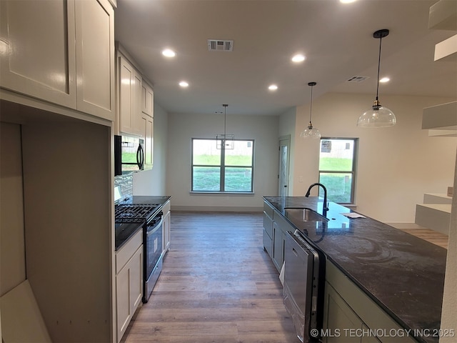 14474 N 50th W Ave, Skiatook, OK 74070 - kitchen featuring dishwashing machine, stainless steel gas range, a sink, dark stone countertops, and light wood-type flooring
