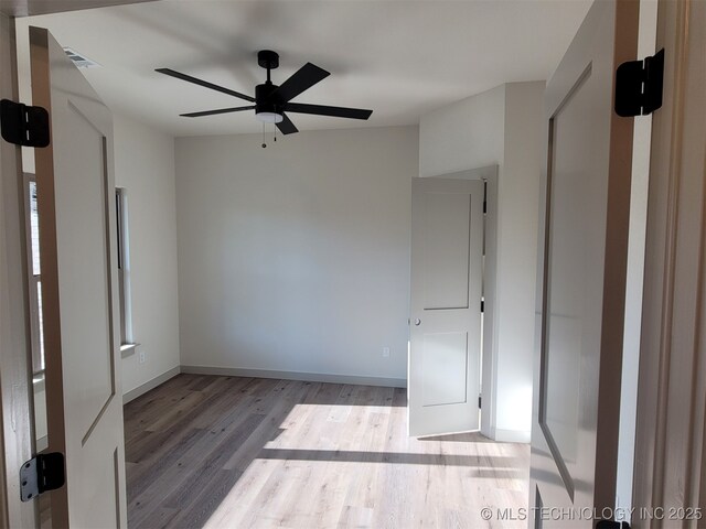 14474 N 50th W Ave, Skiatook, OK 74070 - unfurnished bedroom featuring wood finished floors, baseboards, and ceiling fan