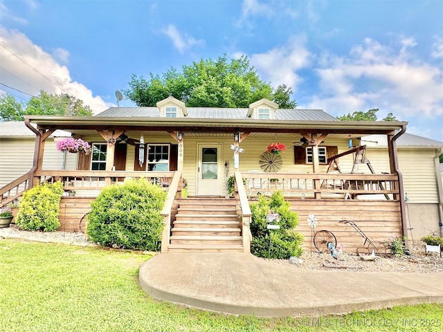 809 N K St, Quinton, OK 74561 - view of front facade featuring covered porch, a ceiling fan, stairway, a front yard, and metal roof