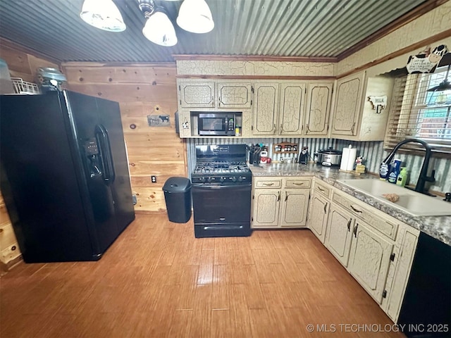 809 N K St, Quinton, OK 74561 - kitchen with black appliances, a sink, light wood-type flooring, and light countertops
