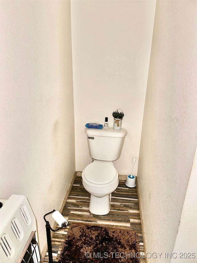 809 N K St, Quinton, OK 74561 - bathroom with toilet, baseboards, wood finished floors, and a textured wall