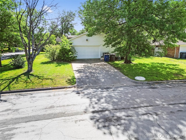 5854 E 46th Pl, Tulsa, OK 74135 - view of property hidden behind natural elements with a front yard, driveway, an attached garage, and brick siding