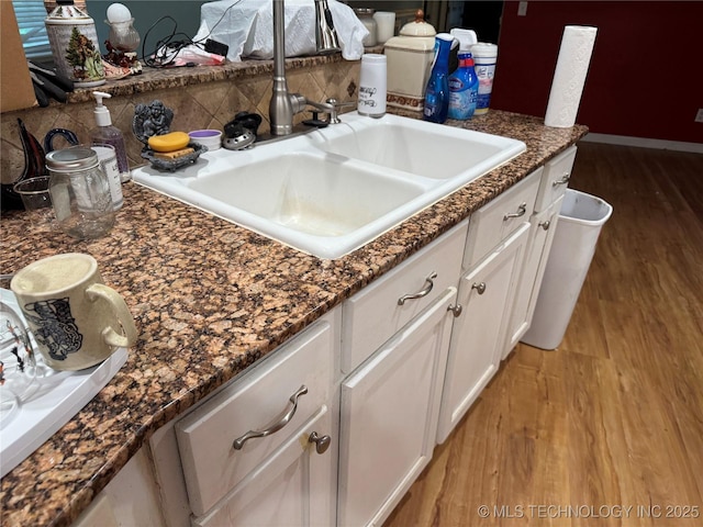 1509 Pawnee Ave, Hartshorne, OK 74547 - kitchen with a sink, light wood-style flooring, white cabinets, backsplash, and baseboards