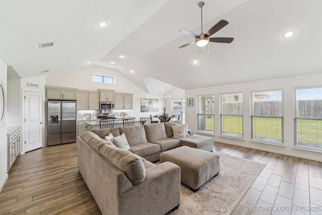 living area with a ceiling fan, high vaulted ceiling, light wood finished floors, and recessed lighting