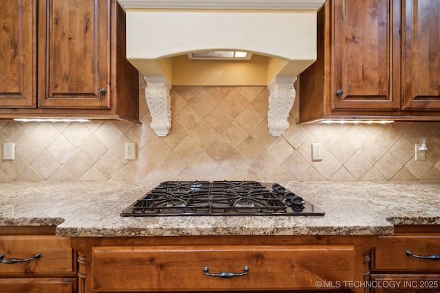 7287 E 111th Pl, Bixby, OK 74008 - kitchen with black gas cooktop, arched walkways, brown cabinets, and extractor fan