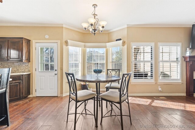5446 E 88th St, Tulsa, OK 74137 - dining room with a chandelier, hardwood / wood-style flooring, baseboards, and ornamental molding