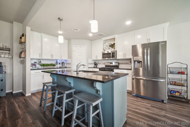3854 E 144th St S, Bixby, OK 74008 - kitchen with stainless steel appliances, a sink, dark wood-style floors, a breakfast bar, and white cabinetry