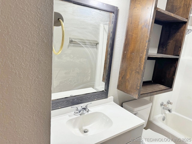 full bathroom featuring a textured wall, toilet, vanity, and shower / bathtub combination