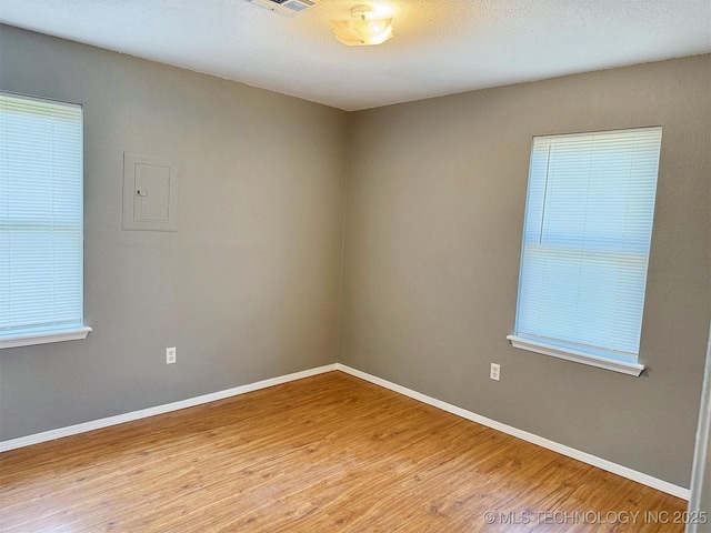 spare room featuring wood finished floors and baseboards