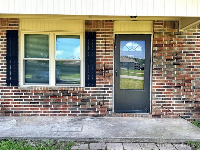 view of exterior entry with brick siding