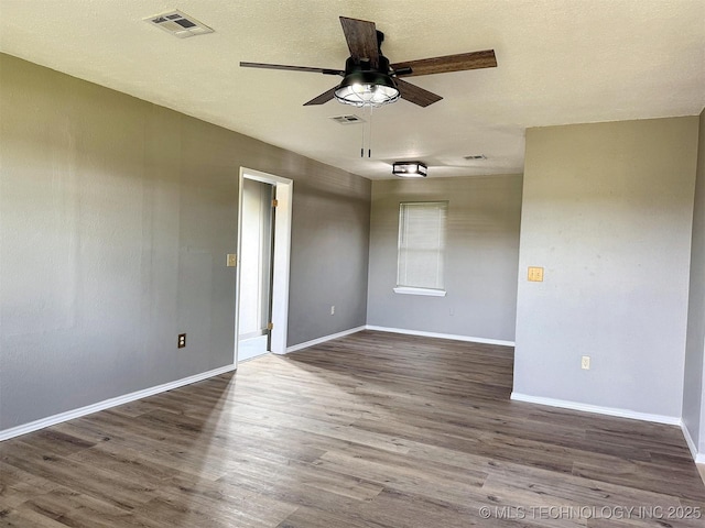 empty room featuring a ceiling fan, wood finished floors, and baseboards