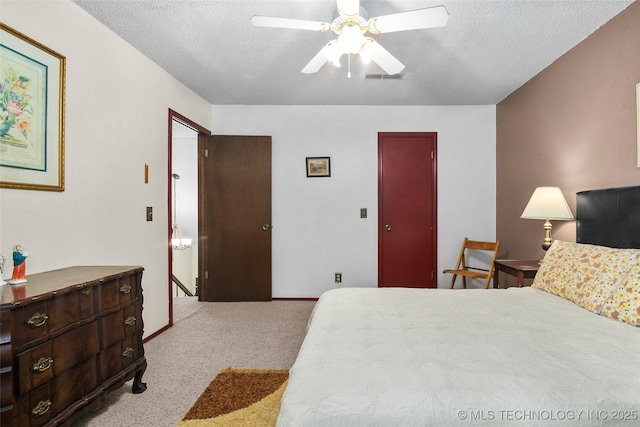 carpeted bedroom featuring a textured ceiling and ceiling fan