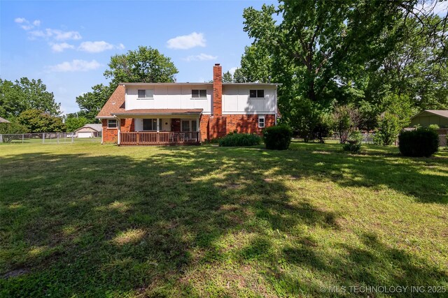 rear view of house with brick siding and a chimney