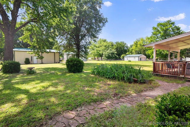 view of green lawn with an outbuilding and a deck