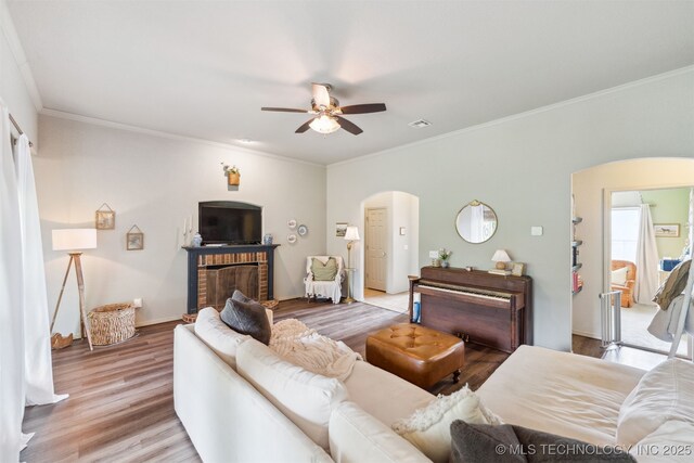 29901 E 137th Pl, Coweta, OK 74429 - living area featuring arched walkways, ceiling fan, light wood finished floors, crown molding, and a brick fireplace